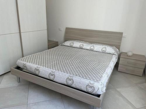 a bed in a small room with a white wall at Appartamento a 400mt dal mare in Cecina