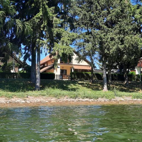 a house on the shore of a body of water at Spacious Apartment "Ana" on lake Sabljaci in Ogulin