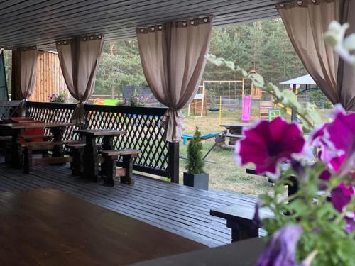 a wooden deck with tables and benches and flowers at Kuru Guest House in Kuru