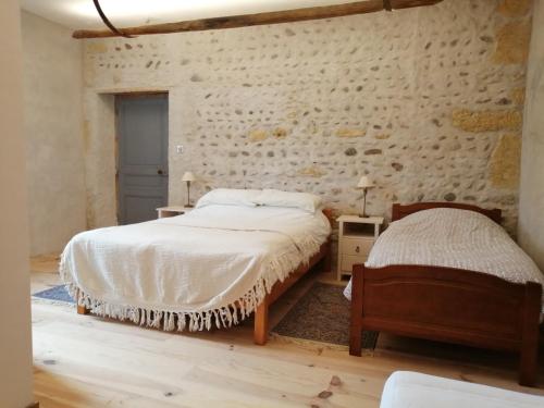 1 Schlafzimmer mit 2 Betten und einer Steinmauer in der Unterkunft Hello Pyrenees in Castelvieilh
