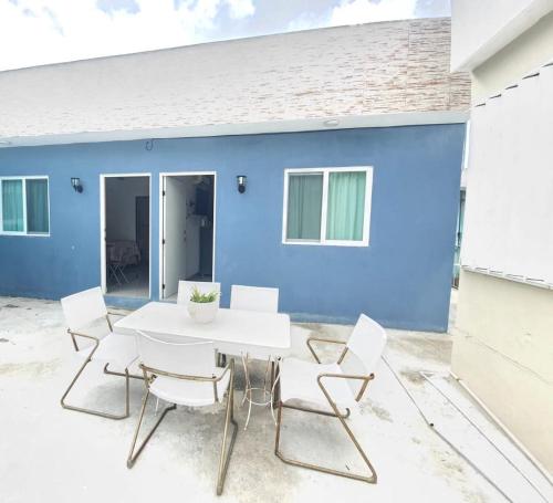 a white table and chairs in front of a blue house at Villa Bonita in Isla Mujeres
