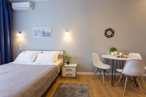 Schlafzimmer mit einem Bett, einem Tisch und Stühlen in der Unterkunft New studio, metro Pushkinska and Universytet - Chernyshevska str. 95-3 in Kharkov