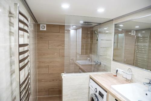 La salle de bains est pourvue d'une douche, d'un lavabo et d'un miroir. dans l'établissement Чарівна квартира-студія на мансардному поверсі!, à Ternopil