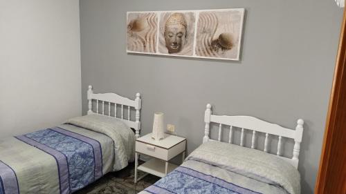 a bedroom with two beds and a picture on the wall at Orzola frente al mar in Orzola