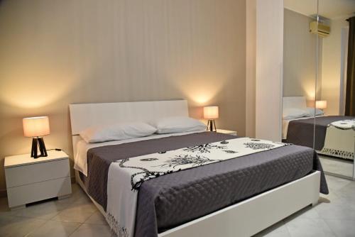 a bedroom with a large bed and two lamps at Casa vacanze LE PALME NETINE in Noto