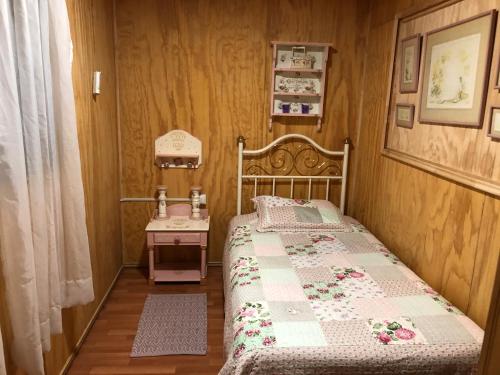 Dormitorio pequeño con cama y mesa en Departamento Amoblado, en Concepción