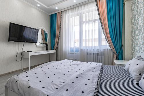 een slaapkamer met een groot bed en een flatscreen-tv bij Apartment with Terrace-Апартаменты с террасой, ЭКСПО, Mega Silky Way in Astana