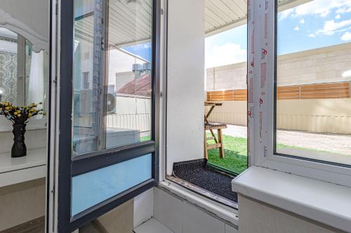 een blik op twee ramen in een huis bij Apartment with Terrace-Апартаменты с террасой, ЭКСПО, Mega Silky Way in Astana