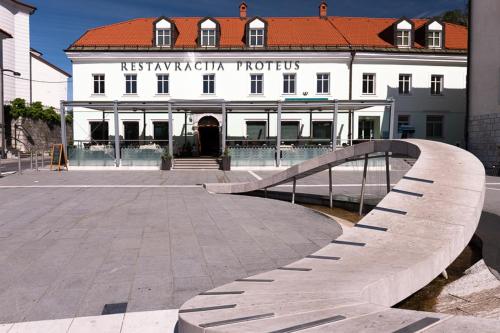 ein Gebäude mit einer Brücke vor einem Gebäude in der Unterkunft Postojna Cave Rooms & Apartments Proteus in Postojna