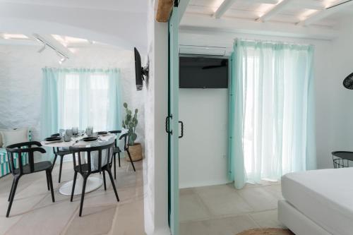 a room with a dining table and a room with a bed at Majo Suites Hotel in Agia Anna Naxos
