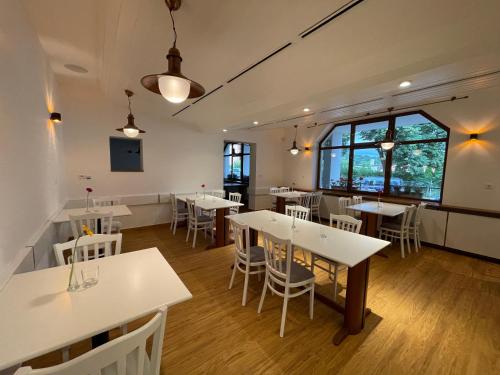 a dining room with tables and white chairs at Hotel Laguna & restaurant in České Budějovice