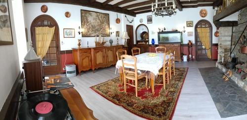 a dining room with a table and a tv at Hostellerie des voyageurs in Cassagnes-Bégonhès