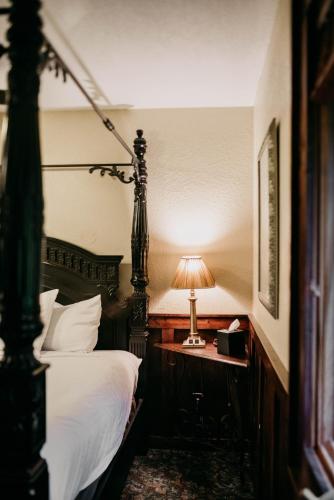 a bedroom with a bed and a lamp on a table at Sylvan Valley Lodge and Cellars in Sautee Nacoochee