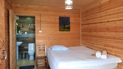 ein Schlafzimmer mit einem Bett in einem Holzzimmer in der Unterkunft Chateau Dio in Ambrolauri
