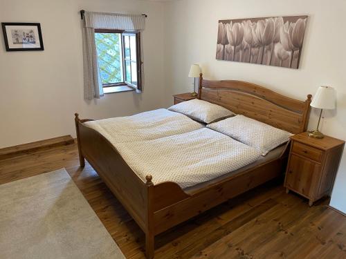 a bedroom with a wooden bed and a window at Apartmány Rožmberk in Rožmberk nad Vltavou