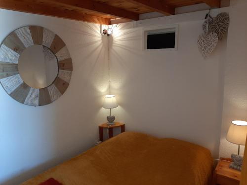 een slaapkamer met een bed en een spiegel aan de muur bij Entre port et village in Gruissan