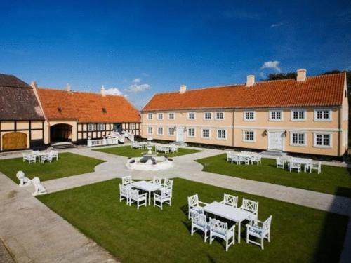 a large building with tables and chairs in a yard at Skrøbelev Gods Manor House in Rudkøbing