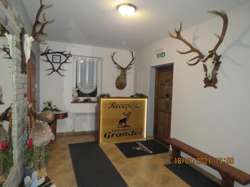 a hallway with deer heads on the wall and a sign at Gościniec Grandel in Bukowina Tatrzańska