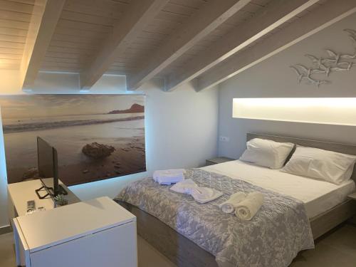 a bedroom with a bed and a painting on the wall at Terpsichore boutique Bright new Sofita studios and appartment in Dassia