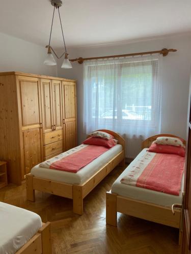 a bedroom with two twin beds and a window at 14 férőhelyes ház saját stéggel, játszótérrel Balatonfenyvesen vízparti utcában in Balatonfenyves