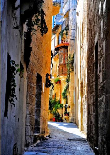 an alley in an old town with buildings at Sunset Modern Apt near the beach in Birżebbuġa