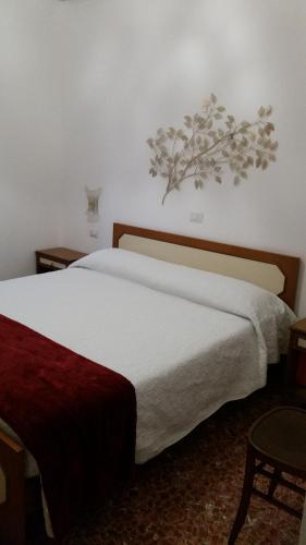 ローマにあるTermini Station apartment AI DUE CORTILI presso le mura aurelianeの白いベッド1台、壁に植物が備わるベッドルーム1室が備わります。