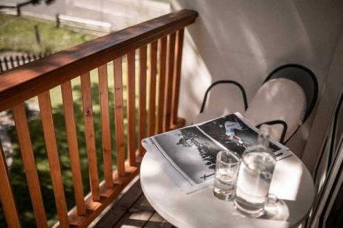 a table with two glasses and a book on a balcony at Hotel Cristallo in Solda