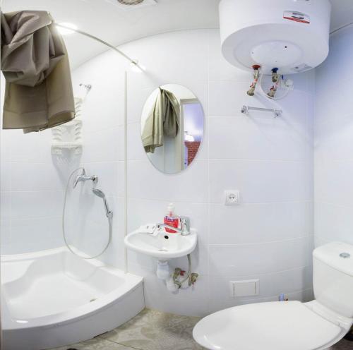 een witte badkamer met een toilet en een wastafel bij Cozy studio in the city center - Mayakovskogo str. 5-1 in Charkov