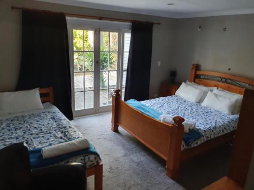 a bedroom with two beds and a window at Koromatua Homestead in Whatawhata