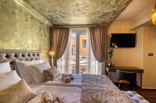 a bedroom with a bed and a desk and a window at Luxury Rooms VINDEMIÆ in Zadar