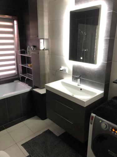 un bagno con un lavandino, una vasca e uno specchio di Apartament Moniuszki a Kędzierzyn-Koźle