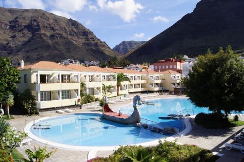 duży basen z górami w tle w obiekcie Apartamentos Checkin Laurisilva w mieście Valle Gran Rey