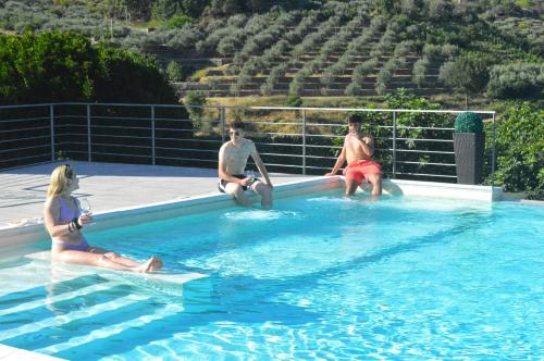 a group of people sitting in a swimming pool at Mauro Home Bed and Relax in Linguaglossa