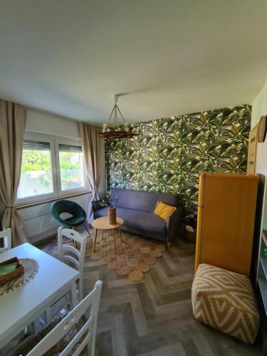 sala de estar con sofá y pared verde en Világos Kert Balatonvilágos Chill House, en Balatonvilágos