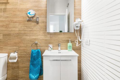 a bathroom with a sink and a toilet and a mirror at El Rincón del Tío de la Tiza in Cádiz