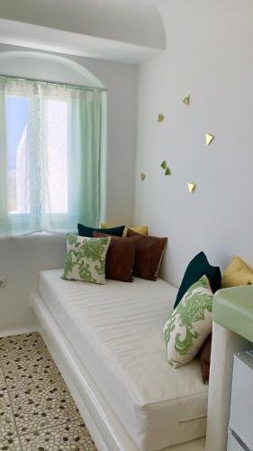 a white couch in a room with a window at Vino suites in Agia Anna Naxos