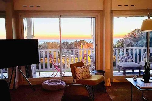 ein Wohnzimmer mit Blick auf einen Balkon in der Unterkunft Appartement de standing vue mer 63 m2 in Trouville-sur-Mer