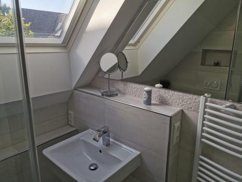 a bathroom with a sink and a mirror at Moderne Wohnung mit Privatpool in Büsum