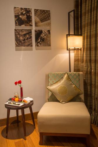 a living room with a chair and a table at Vivanta Colombo, Airport Garden in Negombo