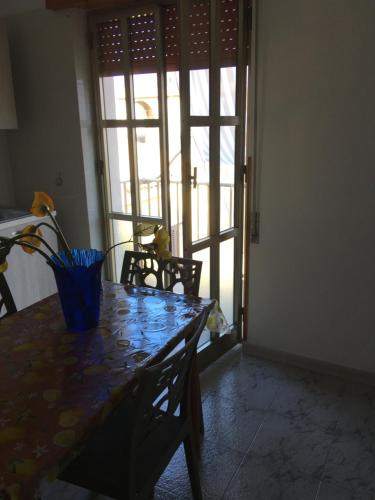 a dining room table with a blue vase on it at Vendicari in Pachino