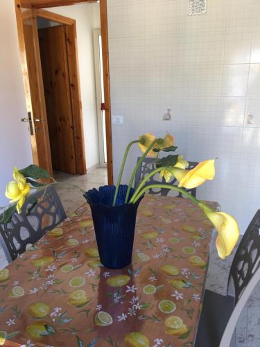 a table with a vase with yellow flowers on it at Vendicari in Pachino