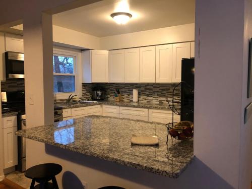 a kitchen with white cabinets and a granite counter top at The Best of the Jersey Shore #airbnb in Long Branch