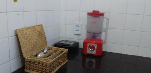 a kitchen with a blender and a basket on a table at Village Lagoinha Ceará in Tigre