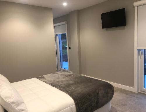 a bedroom with a bed and a television on the wall at Aparthotel Ría de Lires in Lires