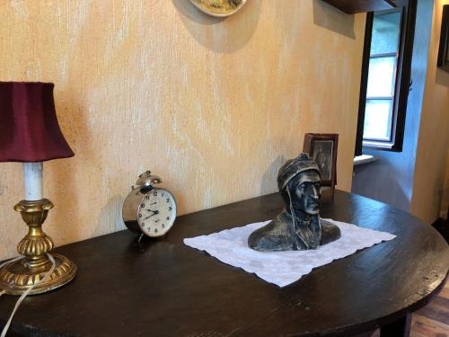a bust of a man sitting on a table next to a clock at Le Primule in Piedilago