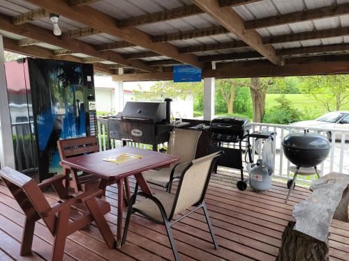 - un barbecue, une table et des chaises sur une terrasse dans l'établissement Little River Inn Motel, à Leon