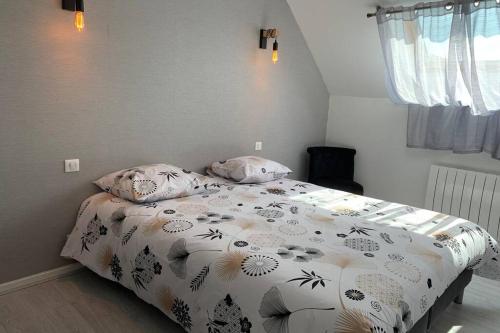 een slaapkamer met een bed met een dekbed erop bij Sans-soucis en plein coeur d'Hautvillers in Hautvillers