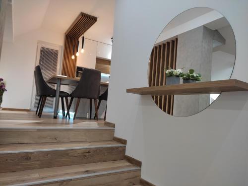 a mirror on a wall next to a dining room at Sky Luxury in Arandjelovac