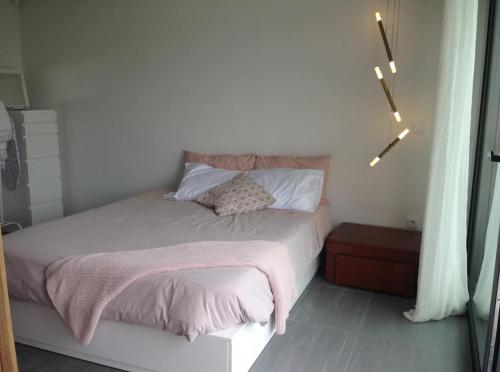 a bedroom with a bed with a pink blanket at AMARÉ Studio in Ovar