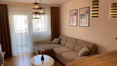 ein Wohnzimmer mit einem Sofa und einem Tisch in der Unterkunft La Perla in Trebinje